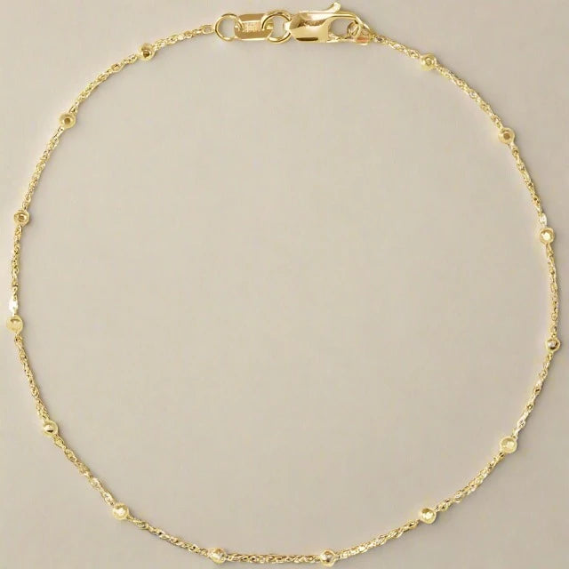 
                      
                        Pear’s The Beaded Bracelet features a delicate, thin gold chain with a lobster clasp closure and small, evenly spaced circular accents that shimmer subtly. Displayed on a simple, light gray background, this elegant piece is both timeless and understated.
                      
                    