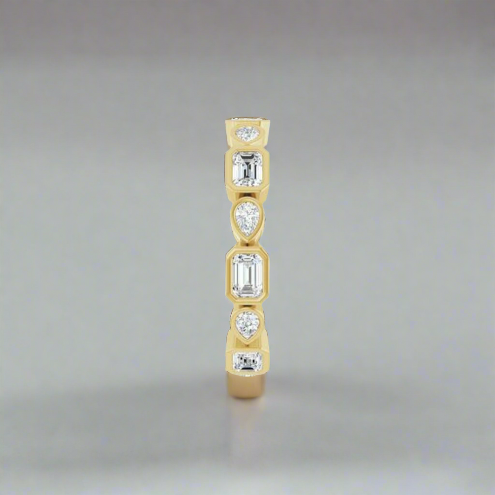 A 1.5 CTW Quinn Diamond Ring by Pear, showcasing a vertical arrangement of round, pear, and rectangular diamonds. The bezel setting accentuates the distinctive shapes and brilliance of each diamond against the gold band.