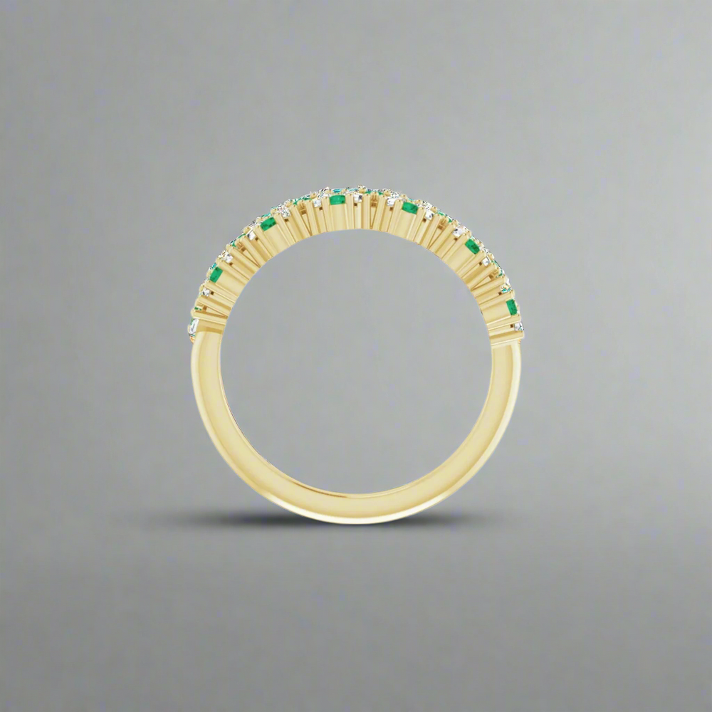 
                      
                        The Eloise Gemstone and Diamond Scattered Ring by Pear features a luxurious design with a row of small green gemstones gracing the top half, elegantly showcased against a plain gradient background.
                      
                    